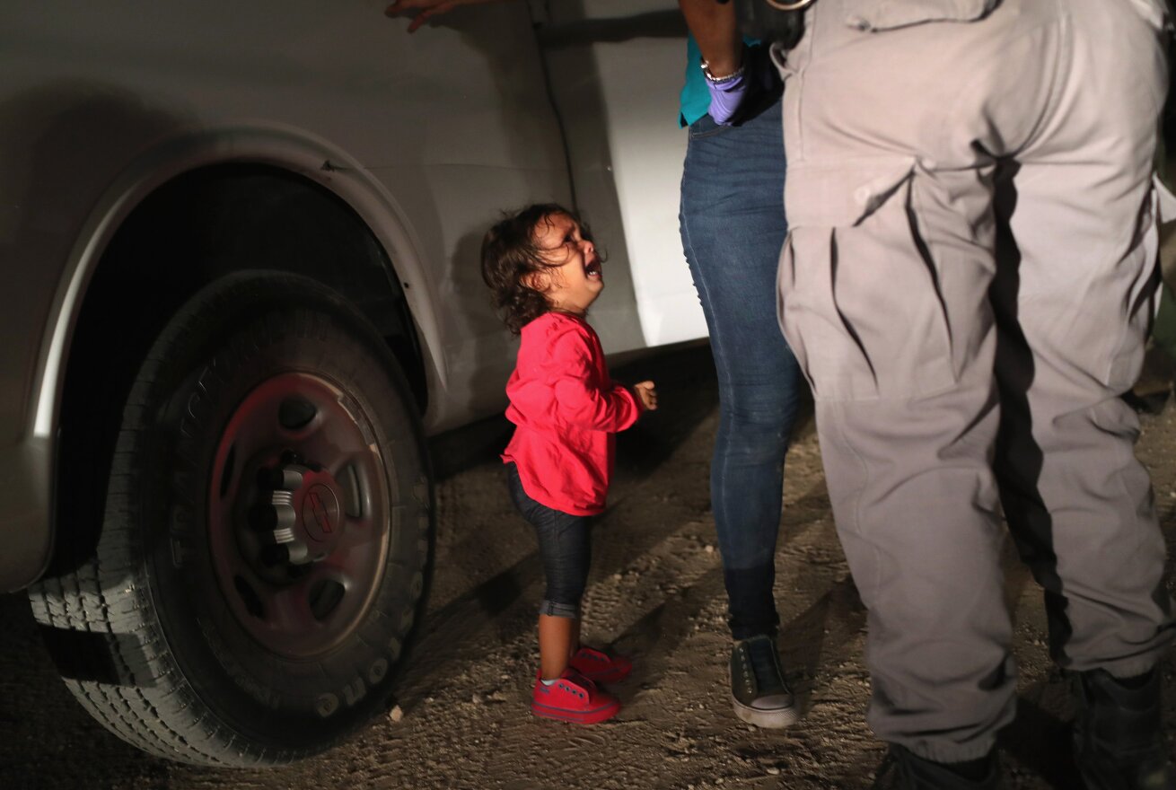 John Moore's June 2018 photograph of a two-year-old Honduran girl watching her mother get searched near the U.S-Mexico border is up for World Press Photo of the Year.